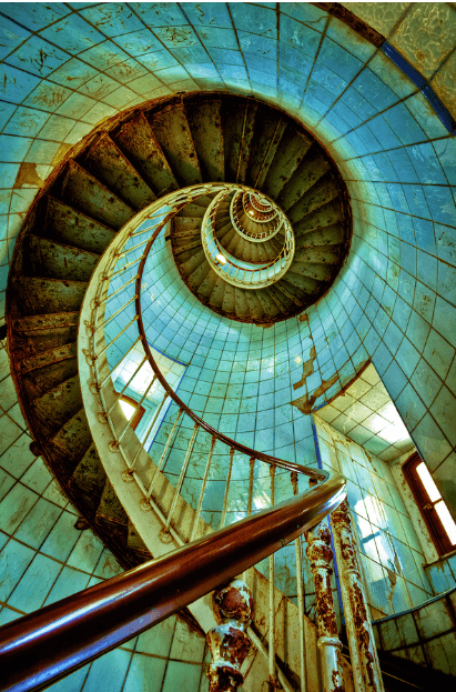 Spiral staircase viewed from below, showcasing intricate design and light.